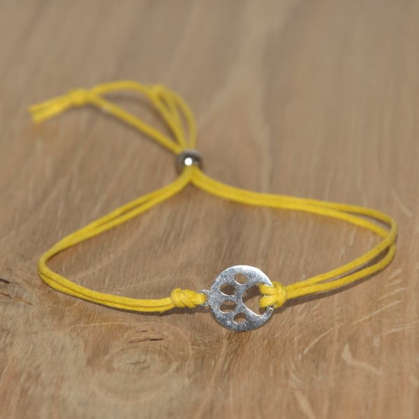 Armband aus gewachster Baumwolle in gelb mit Charm "Pfote" aus Edelstahl 304 und Schiebeverschluss mit Perle aus Edelstahl 304